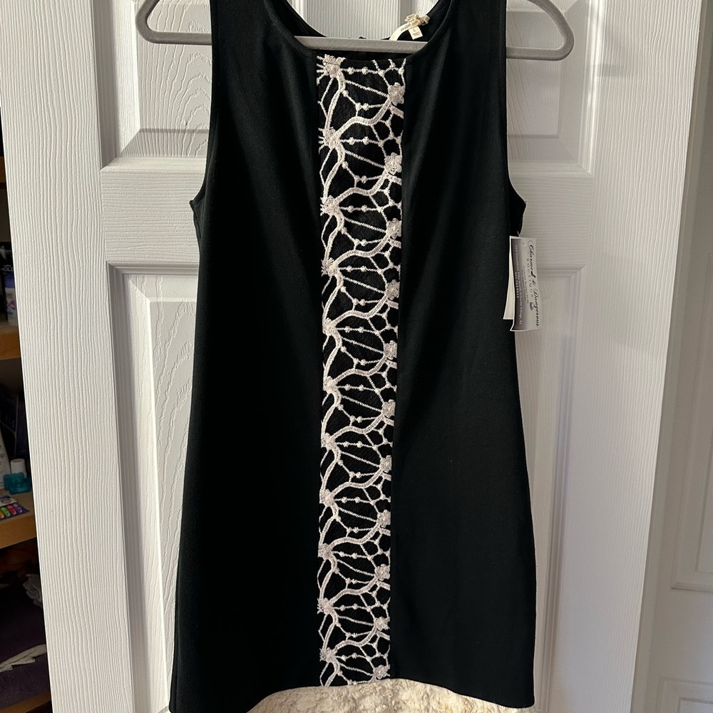 Beautiful sleeveless black dress with cream trim.
